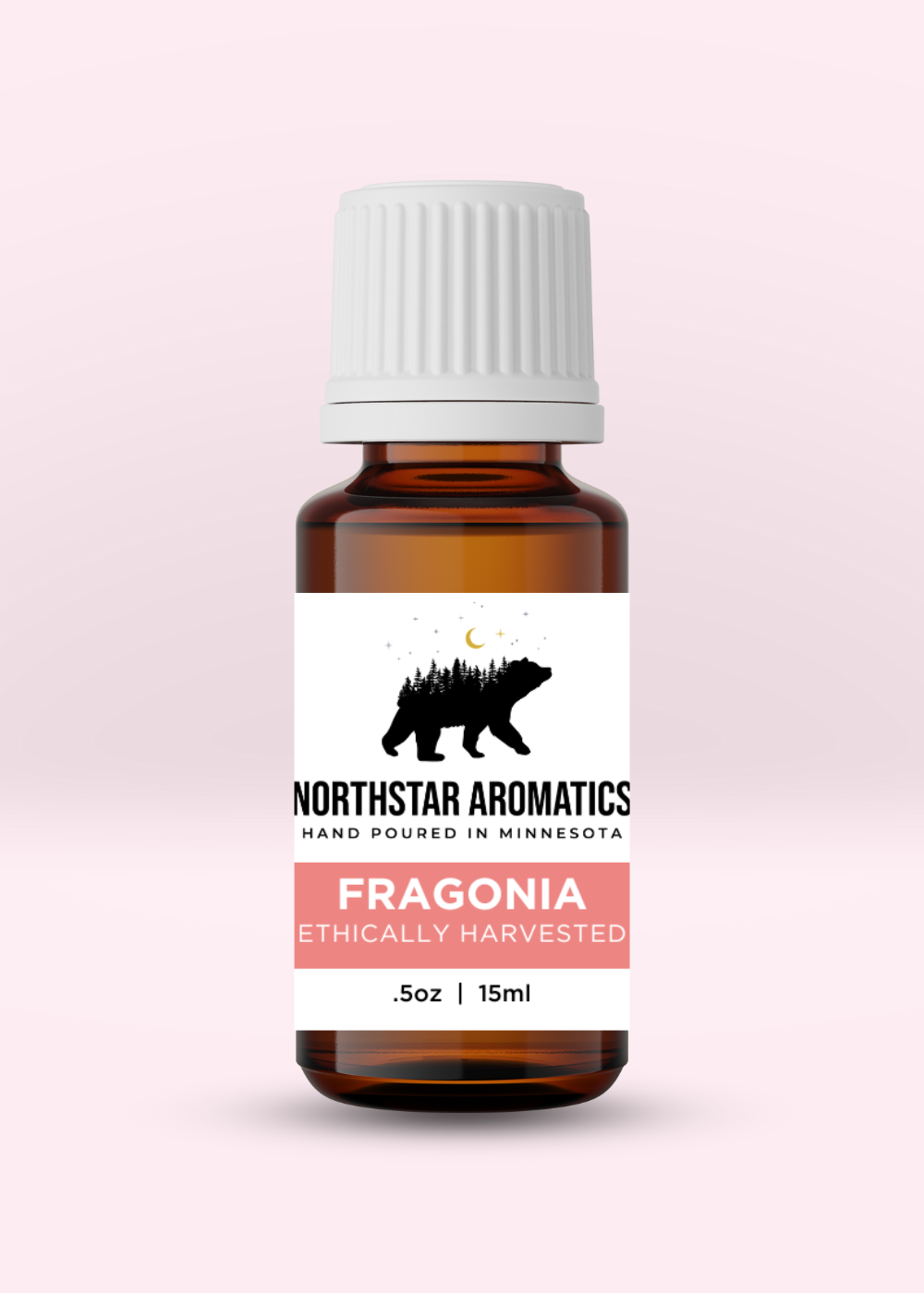 Amber glass bottle of Fragonia essential oil by Northstar Aromatics with white ribbed cap on soft light pink background