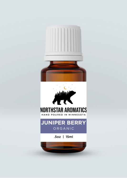 Amber glass bottle of Juniper Berry organic oil with white ribbed cap and Northstar Aromatics label on light gray background