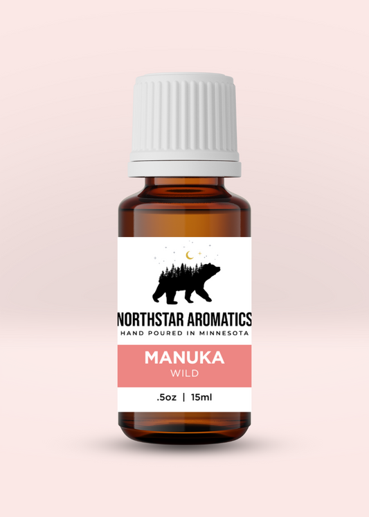 Amber glass bottle of Manuka Wild essential oil by Northstar Aromatics with white ribbed cap on light pink background