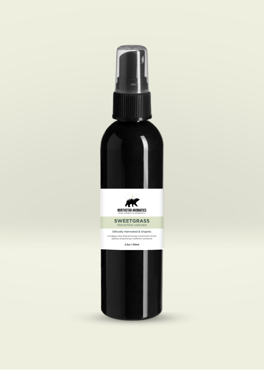 Black plastic spray bottle of organic Sweetgrass hydrosol by Northstar Aromatics on soft beige background
