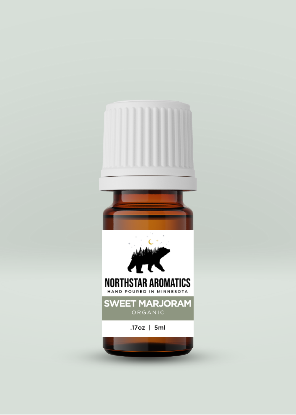 Amber bottle of organic Sweet Marjoram essential oil with white ribbed cap and Northstar Aromatics forest-themed label on pale green-gray background