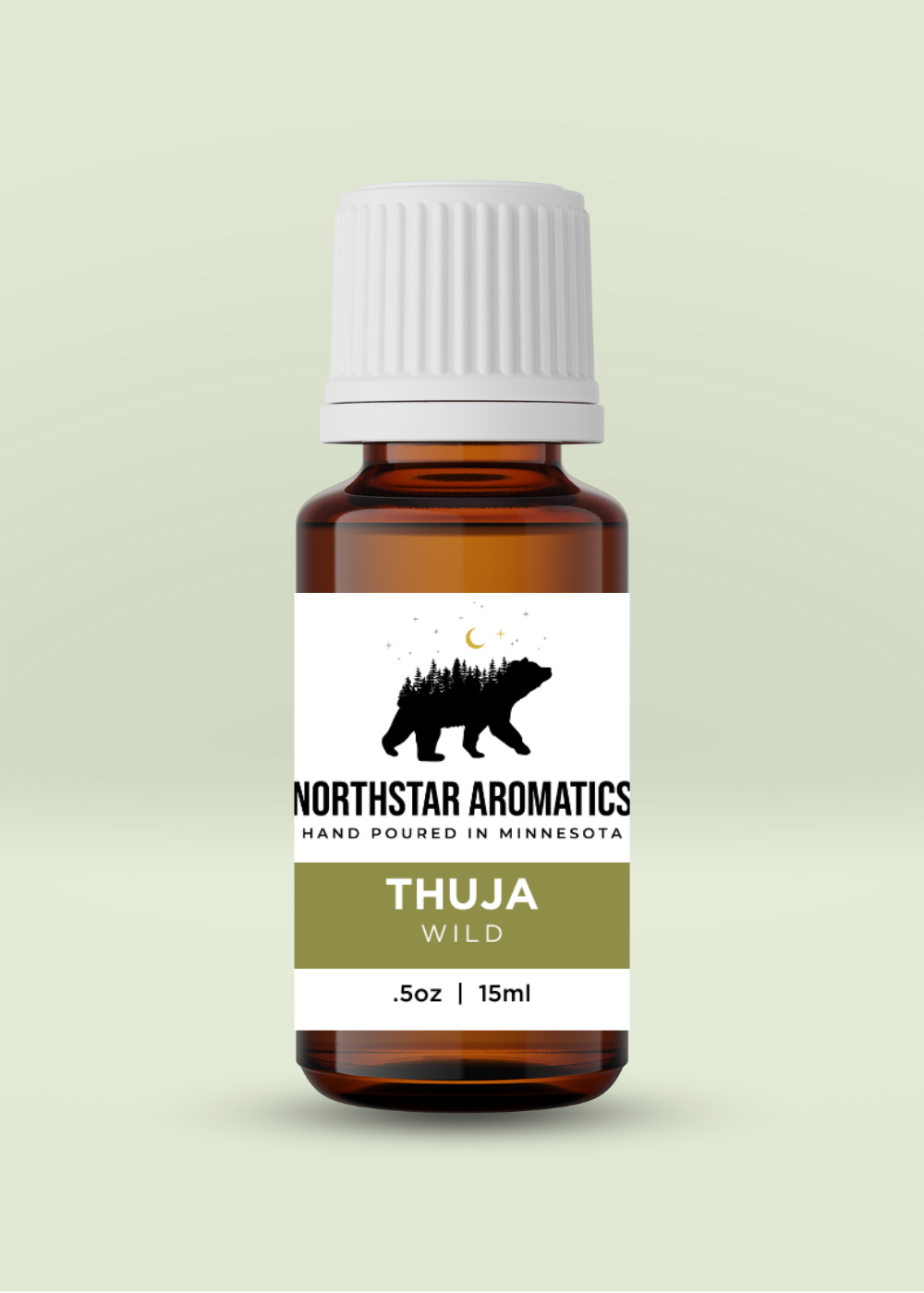 Amber glass bottle of Thuja essential oil with white cap and nature-inspired label on pale green background