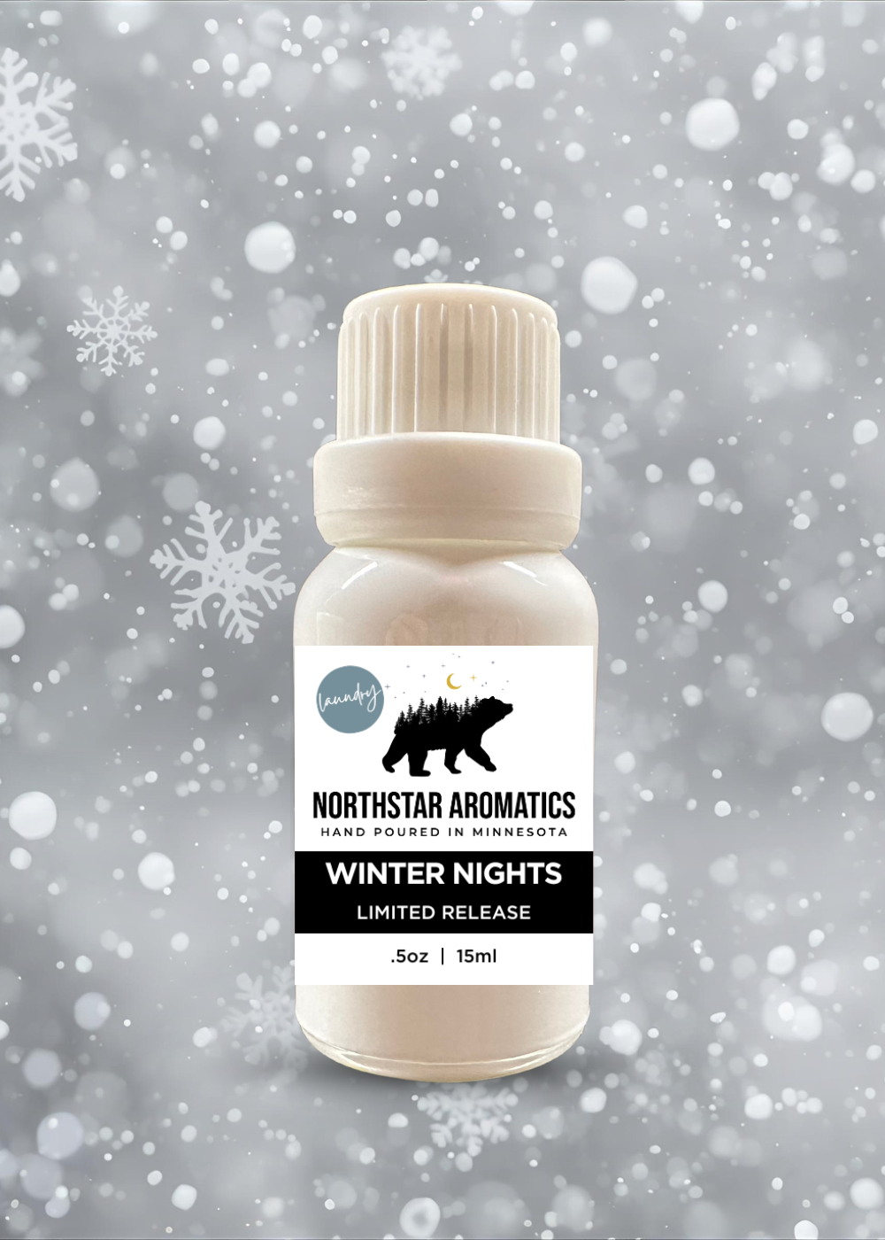 Small bottle of Winter Nights limited edition laundry oil with snowy background and falling snowflakes