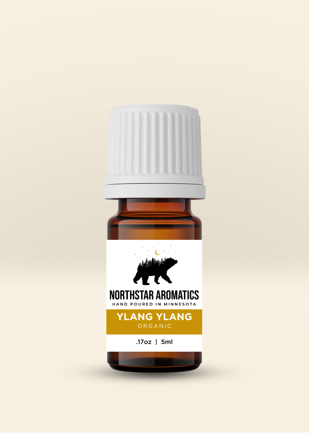 Small amber glass bottle of organic Ylang Ylang oil by Northstar Aromatics with white ribbed cap on beige background