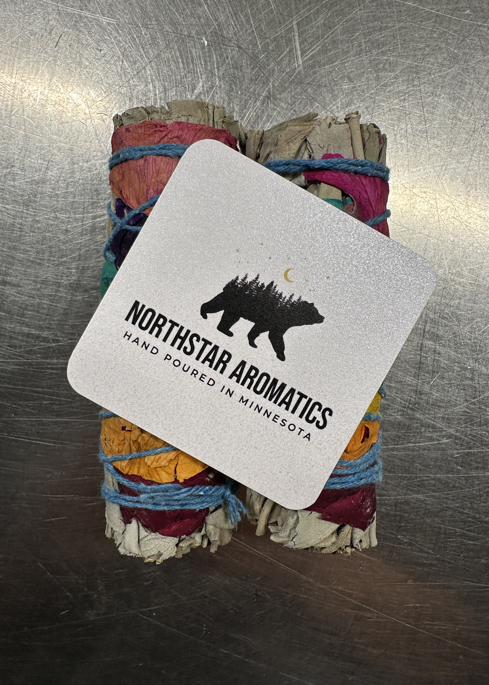 Chakra White Sage Smudge bundles wrapped with rainbow rose petals, handmade by Northstar Aromatics.