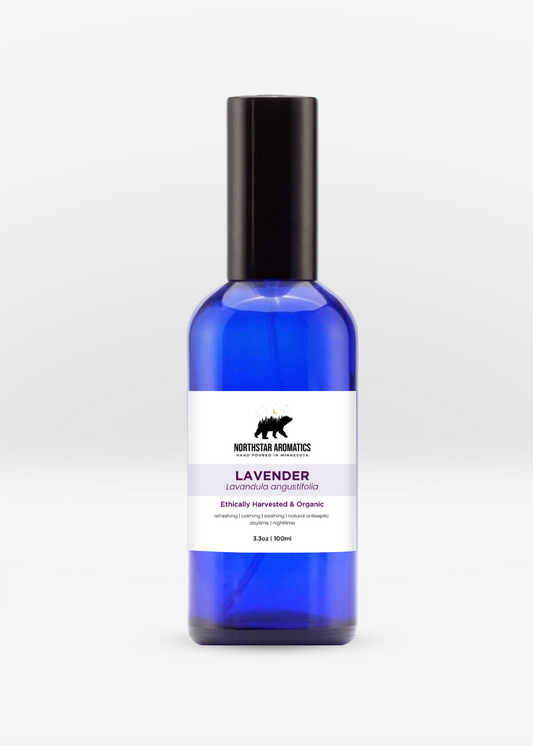 Blue glass spray bottle of Lavender hydrosol by Northstar Aromatics with black cap on white background